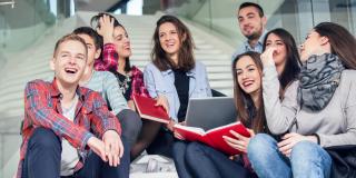Schülerinnen und Schüler sitzen auf einer Treppe