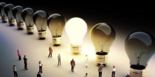 Eine leuchtende Glühbirne und viele Menschen die darauf zugehen