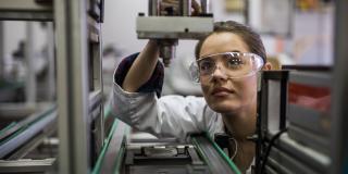 Eine Frau steht vor einem Mikroskop