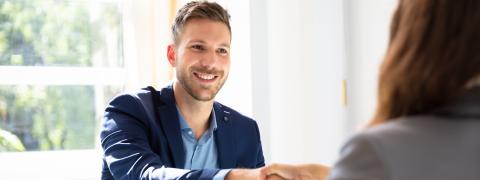 Ein Mann schüttelt einer Frau die Hand