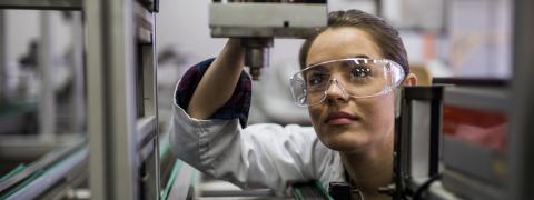 Eine Frau steht vor einem Mikroskop